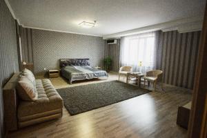 a bedroom with a bed and a couch and a table at Park EmpAir Hotel in Pavlodar