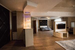 a large living room with a bed and a television at Park EmpAir Hotel in Pavlodar +1 photo