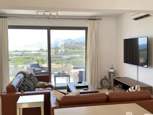 a living room with a couch and a large window at Luxury Lagada Loft Sea Views in Pilalímata