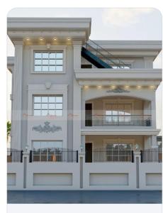 een wit huis met een trap erop bij Shree Radha Bhavan in Heṭauḍā