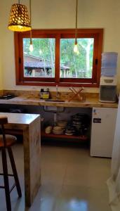 a kitchen with a counter and a sink and two windows at Casa Miava - Studio 1 in Marau