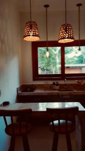 a kitchen with a table and two chairs and lights at Casa Miava - Studio 1 in Marau