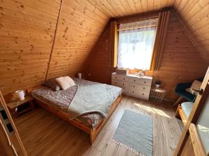 een slaapkamer met een bed in een houten hut bij Domek Mateo in Wambierzyce