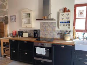 a kitchen with a counter top and a sink at La Petite Maison à Beaulieu in Beaulieu-sur-Dordogne +8 photos