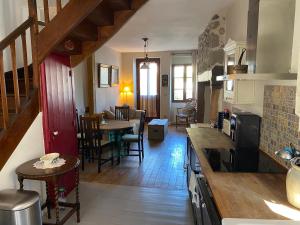 a kitchen and living room with a table and chairs at La Petite Maison à Beaulieu in Beaulieu-sur-Dordogne