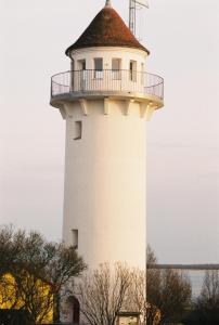 un faro bianco con un tetto sopra di Lotsenturm Usedom a Karnin