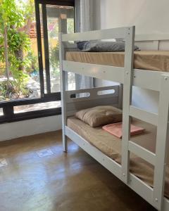 een kamer met twee stapelbedden en een raam bij Casa de Cura in Pipa