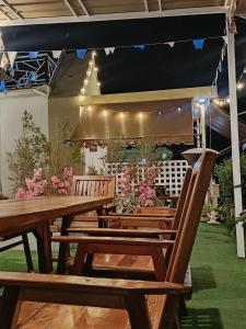 un gruppo di panche di legno sedute sotto una tenda di มินิฮาร์ท เฮาส์บีช Mini Heart House Beach a Ban Chak Phai