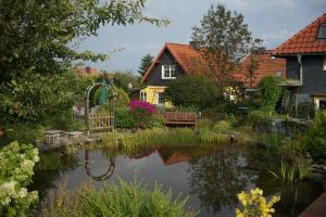 een tuin met een vijver voor een huis bij Ferienwohnung Dorle in Benneckenstein