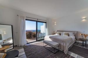 a white bedroom with a bed and a large window at Amazing Views Villa in Loulé +8 photos