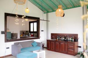 a living room with a blue couch and a bar at Black Lantern in Matara