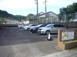 un estacionamiento con un montón de coches aparcados en Hotel Crown Hills Nakamura, en Shimanto
