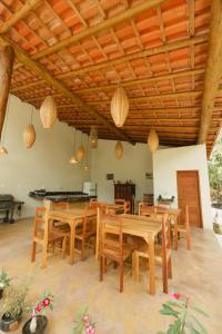 een eetkamer met houten tafels en stoelen bij Jardim do Wape in Santa Cruz Cabrália
