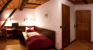 een slaapkamer met een bed, een bureau en een deur bij Gasthof Waldgericht in Dornstetten