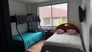 a bedroom with a bunk bed and a window at Villa Mariaclaudia in Macas