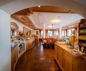 a kitchen with wooden cabinets and a dining room at Hotel Trisanna in Ischgl +150 photos