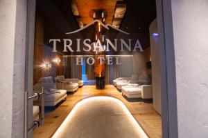a lobby of a hotel with white couches and a sign at Hotel Trisanna in Ischgl