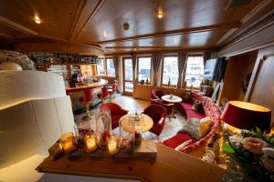 a living room with a table and red chairs at Hotel Trisanna in Ischgl