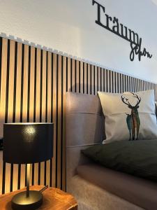 een slaapkamer met een bed en een tafel met een lamp bij WälderNestchen - zentral - Natur pur - Tiefgarage - Balkon - modernes 2 Zimmer Appartement in Lenzkirch