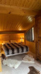 a bedroom with a bed in a wooden cabin at Red Fir Chalet in Megève