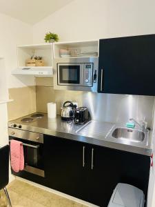 a small kitchen with a sink and a microwave at Riverlight Studio sleep 3 in Cambridge +8 photos