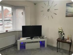 a living room with a large clock on the wall at NG Property in Glasgow