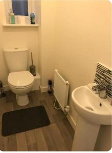a bathroom with a white toilet and a sink at NG Property in Glasgow