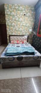 un letto in una camera da letto con parete floreale di Shakti HomeStay - Kashi Dham a Varanasi