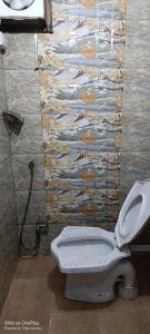 bagno con servizi igienici e parete in pietra di Shakti HomeStay - Kashi Dham a Varanasi Altre 12 foto