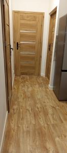 een lege kamer met houten deuren en houten vloeren bij Apartamenty na Witosa in Nowa Sól