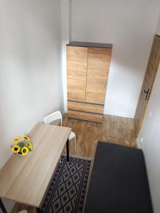 een kleine kamer met een houten tafel en een kast bij Apartamenty na Witosa in Nowa Sól