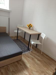 een tafel met twee stoelen en een tafel met bloemen erop bij Apartamenty na Witosa in Nowa Sól