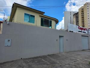 a white wall with a house on top of it at Cerrado Hostel in Goiânia