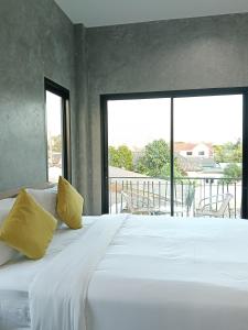 a bedroom with a large white bed with yellow pillows at Loft Life Pool villa in Ban Huai Yai +118 photos