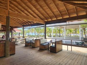 een paviljoen met tafels en stoelen op een houten terras bij Sea Eye Hotel - Laguna Building in Utila