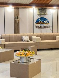 a lobby with a tray of fruit on a table at RAM HORlZON BUBBLE LUXURY CAMP in Wadi Rum