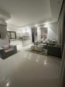 een grote woonkamer met banken en een tafel bij منتجع هوانا غرفتين in Salalah