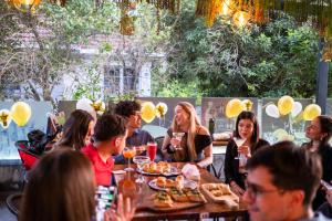 a group of people sitting at a table eating food at Hotel Boutique Holitel in Santiago