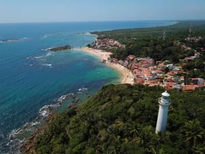 an aerial view of a beach with a lighthouse at Casa Varandão, 1ª praia, Morro de São Paulo in Cairu