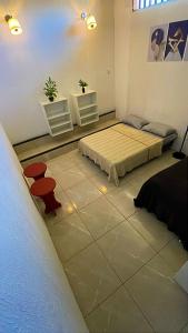 a bedroom with two beds and two chairs in it at Hostel Mariah in Cabo Frio