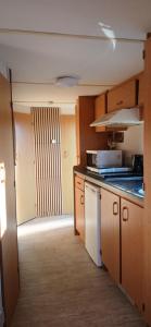 a kitchen with a sink and a stove top oven at Stacaravan op de paardenboerderij Sneek in Sneek +36 photos