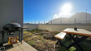 a picnic table and a grill and a picnic table at Steps from the beach , Muizenberg home in Muizenberg