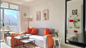 a living room with a couch and a table at Steps from the beach , Muizenberg home in Muizenberg
