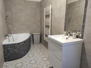 een badkamer met een bad, een toilet en een wastafel bij Garden Home in Törökbálint