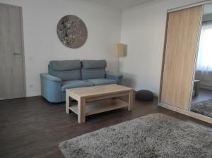 een woonkamer met een blauwe bank en een salontafel bij Garden Home in Törökbálint