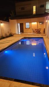 a large swimming pool with blue water at night at Dúplex Lagoa in Paracuru