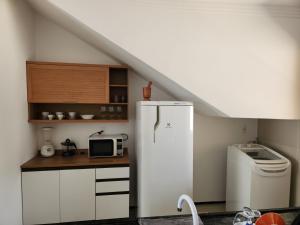 a kitchen with a refrigerator and a microwave at Dúplex Lagoa in Paracuru +4 photos
