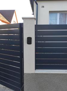 een zwarte poort voor een huis bij Garden Home in Törökbálint