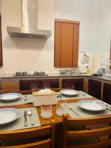 a kitchen with a wooden table with plates on it at Aonang Peace Pool Villa in Ban Khlong Haeng