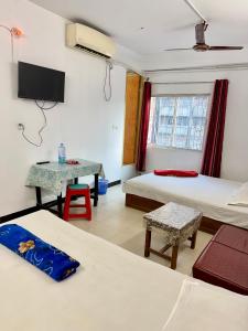 Camera con 2 Letti, tavolo e TV di Hotel Rose International a Dhaka